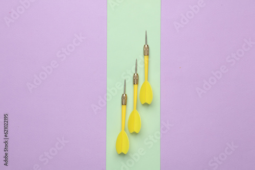 Darts needles on colored pastel background. Top view
