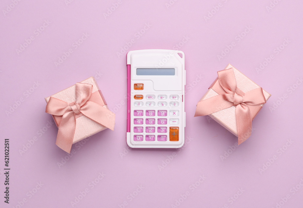 Gift boxes and calculator on pink background. Top view Gift boxes and calculator on pink background. Top view