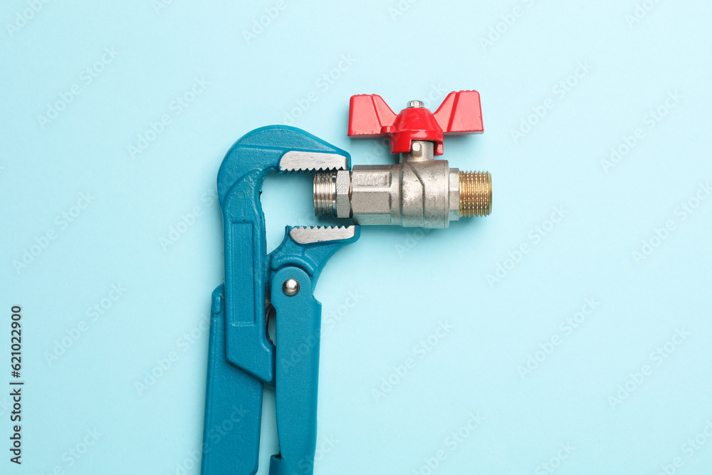 Adjustable wrench with ball valve on a blue background