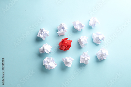 Crumpled white and red balls of paper on a blue background. Leadership, uniqueness, business concept