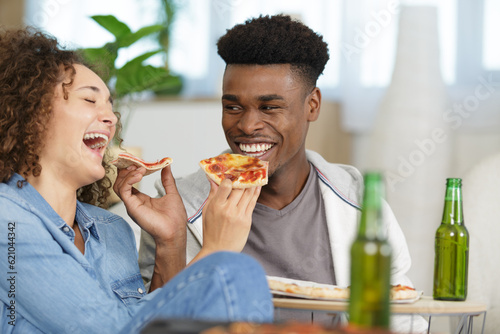 happy couple laughing and eating pizza