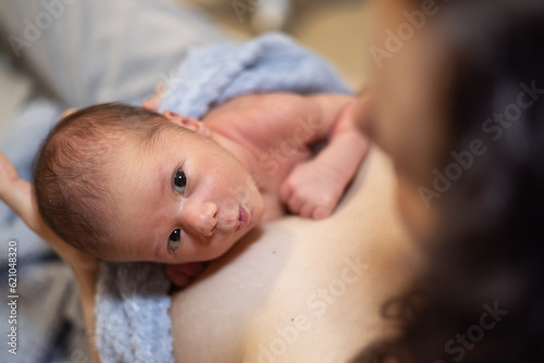 Принти на полотні Adorable Newborn Baby Boy sitting on mother chest.