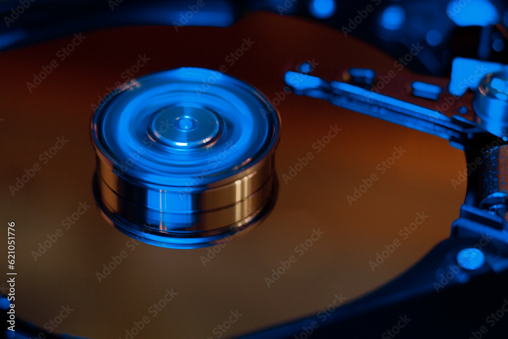 Computer hard drive without protective cover. Close up of hard disk with abstract reflection. Opened hard drive from the computer hdd with mirror effects Part of computer pc. Soft selective focus Computer hard drive without protective cover. Close up of hard disk with abstract reflection. Opened hard drive from the computer hdd with mirror effects Part of computer pc. Soft selective focus