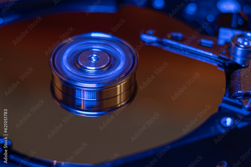 Computer hard drive without protective cover. Close up of hard disk with abstract reflection. Opened hard drive from the computer hdd with mirror effects Part of computer pc. Soft selective focus Computer hard drive without protective cover. Close up of hard disk with abstract reflection. Opened hard drive from the computer hdd with mirror effects Part of computer pc. Soft selective focus