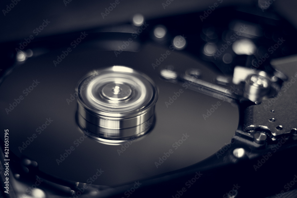 Computer hard drive without protective cover. Close up of hard disk with abstract reflection. Opened hard drive from the computer hdd with mirror effects Part of computer pc. Soft selective focus Computer hard drive without protective cover. Close up of hard disk with abstract reflection. Opened hard drive from the computer hdd with mirror effects Part of computer pc. Soft selective focus