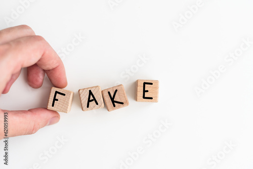 Closeup of businesswoman hold a cubes with word FAKE