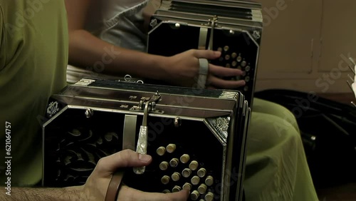 Two Musicians Playing the Bandoneon inside a House of La Boca, Buenos Aires, Argentina. Close Up. 4K Resolution. photo