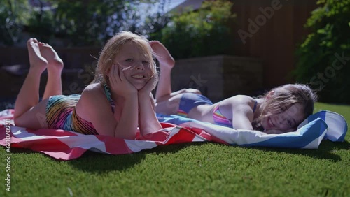 Portrait of two girls laying down near a swimming pool