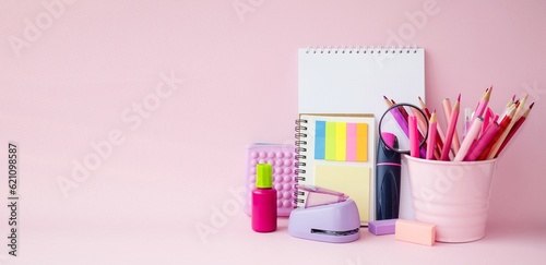 On a pink background, school supplies for drawing and learning. Notebooks, notebooks, pencils and markers. Copy space for text, front view, background. Concept back to school.