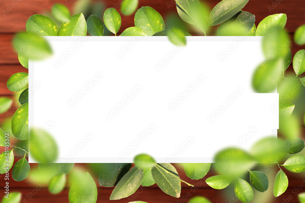 Green leaves frame on wooden background with copy space.