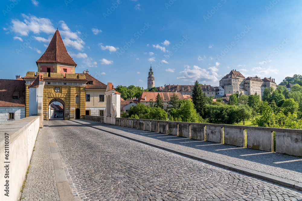 Cesky Krumlov yellow city wall gate with bridge over the moat, below the Gothic castle