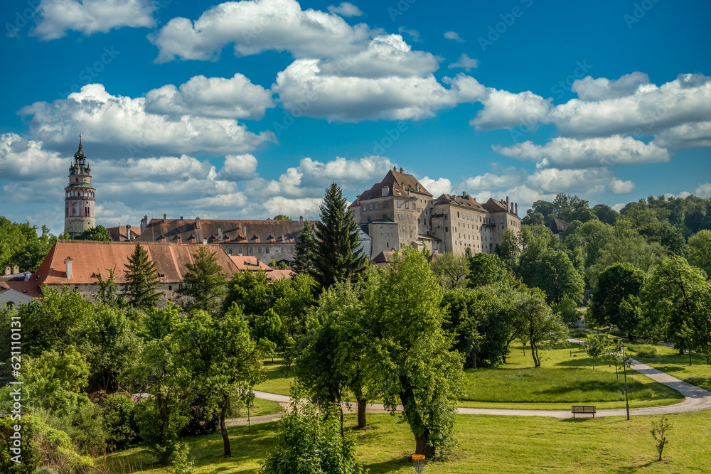View of Cesky Krumlov castle from the town park with cloudy blue sky