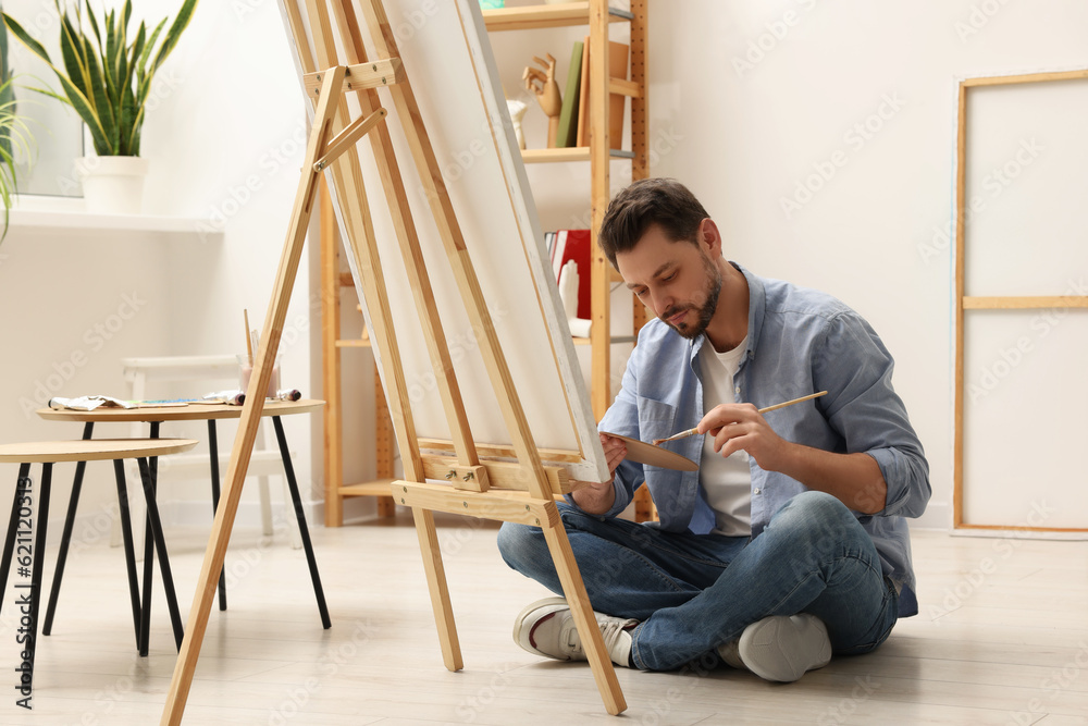 Handsome man painting in studio. Creative hobby
