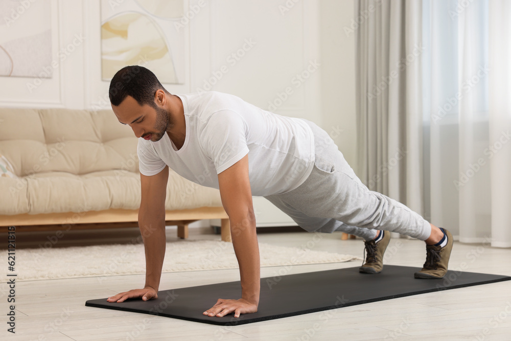 Man doing morning exercise on fitness mat at home Man doing morning exercise on fitness mat at home