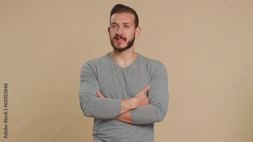 Lebanese man show thumb down, dislike and saying No, be careful, scolding, giving advice to avoid danger mistake, disapproval sign. Young guy isolated on beige studio background. People lifestyles Lebanese man show thumb down, dislike and saying No, be careful, scolding, giving advice to avoid danger mistake, disapproval sign. Young guy isolated on beige studio background. People lifestyles