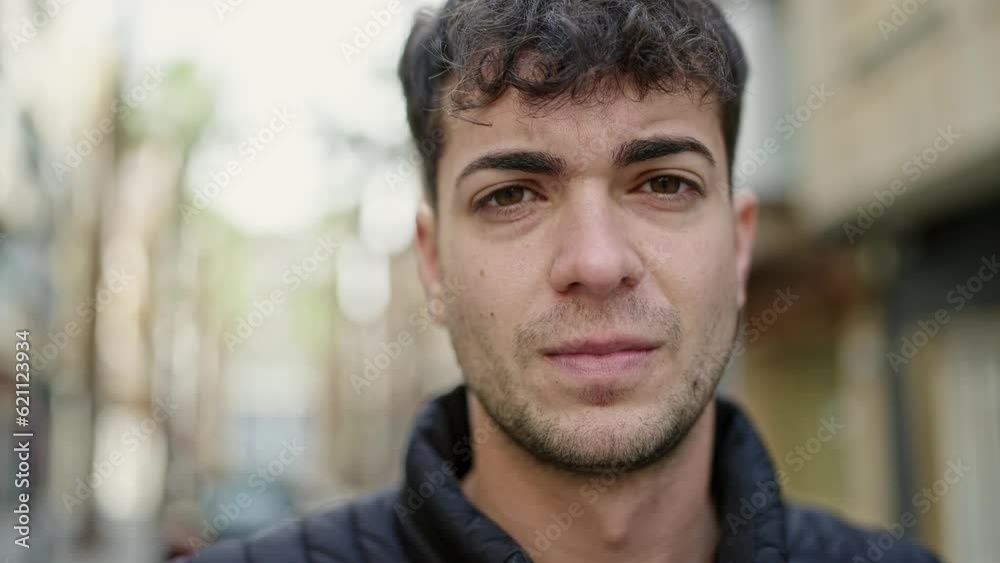Young hispanic man standing with serious expression at street Young hispanic man standing with serious expression at street