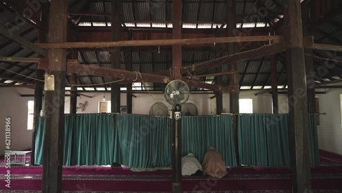 Two Indonesian Women Salah ( Salat ) inside an Traditional Old Mosque Indonesia