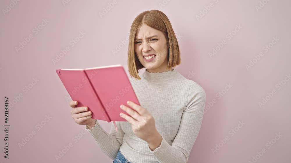 Young blonde woman reading book looking upset over isolated pink background Young blonde woman reading book looking upset over isolated pink background