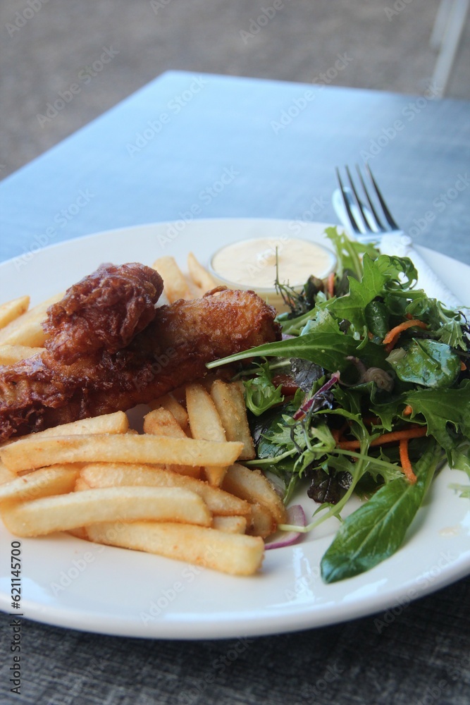 Delicious fish and chips served with vegetables on a plate. Delicious fish and chips served with vegetables on a plate.