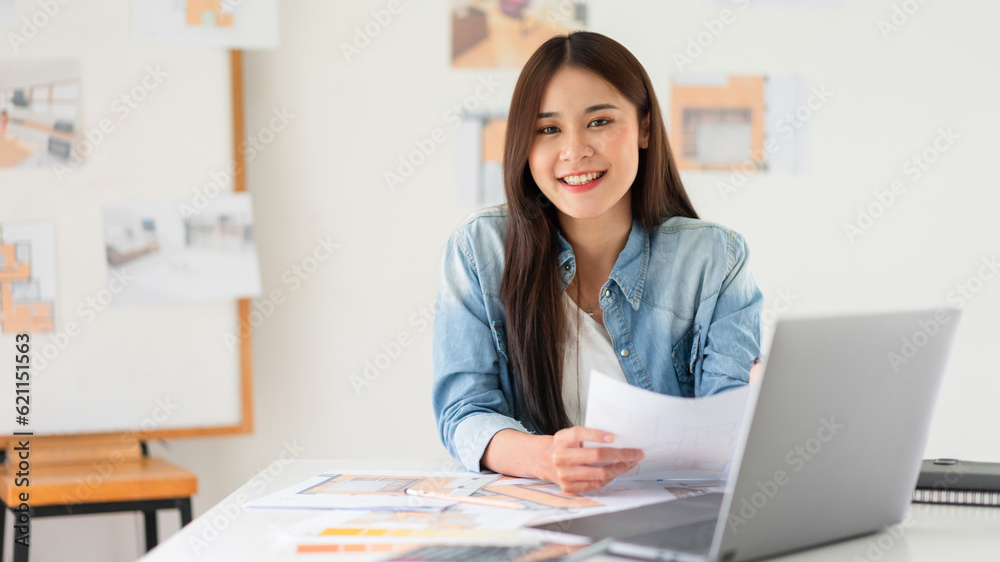 Design building concept, Female architect holding blueprint of house plan and smiling on camera Design building concept, Female architect holding blueprint of house plan and smiling on camera