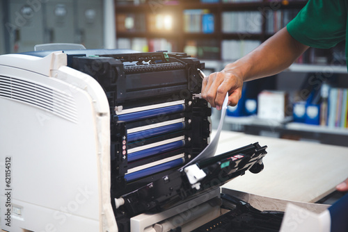 Technician hand open cover photocopier or photocopy to fix repair copier paper jam and replace ink cartridges for scanning fax or copy document in office workplace.