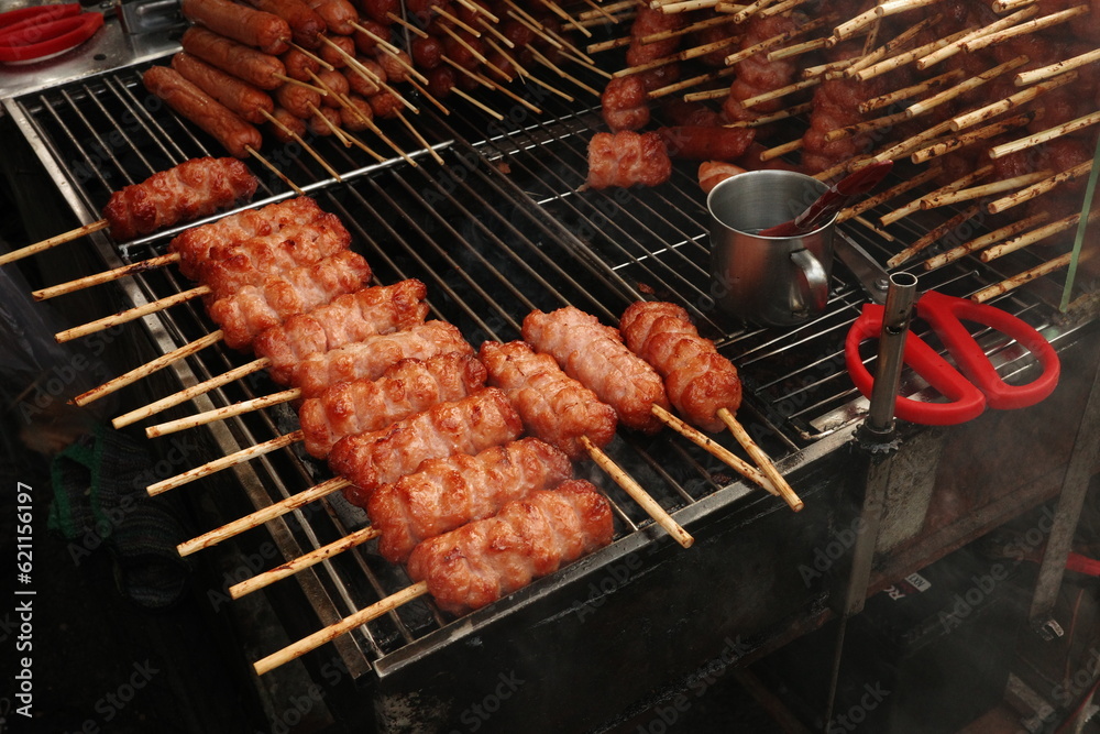 Grilled pork sausage on charcoal. Nem nuong Ninh Hoa on street of Hi Chi Minh city, Viet Nam. One of many yummy local foods in town.