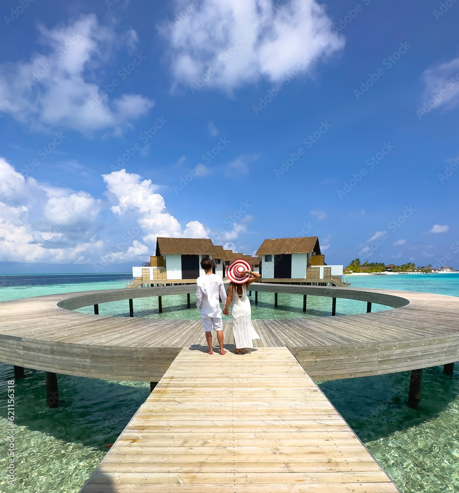 Happy moment with Couple in white dress on a beach jetty at Maldives
