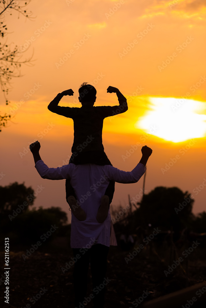 Fototapeta premium Father carrying son on shoulders on field against sky