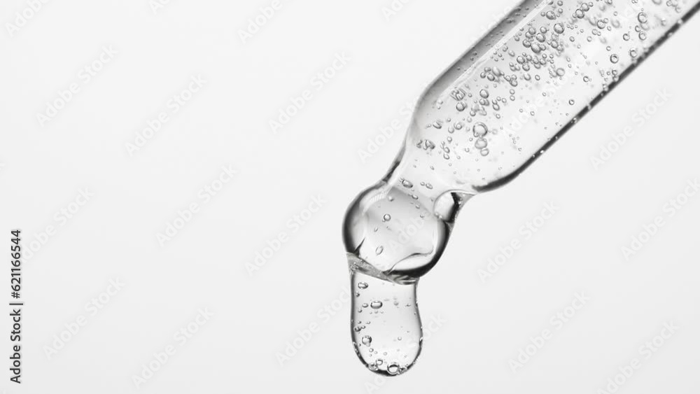 Closeup cosmetic serum fluid gel with bubbles from dropper, pipette over white