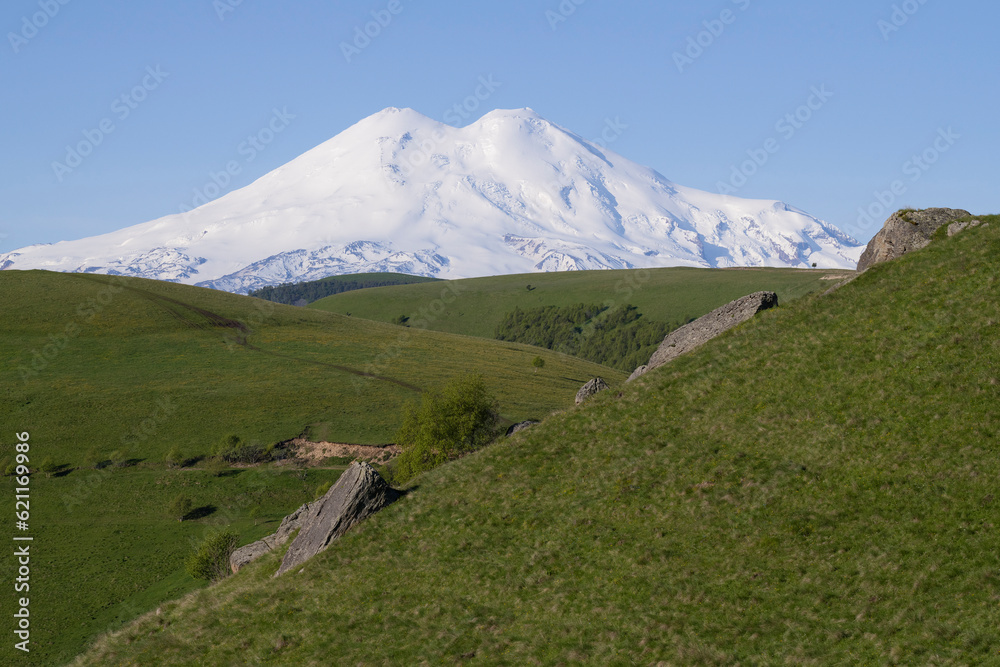View of Elbrus from the alpine meadow on a sunny June morning. Kabardino-Balkaria, Russia