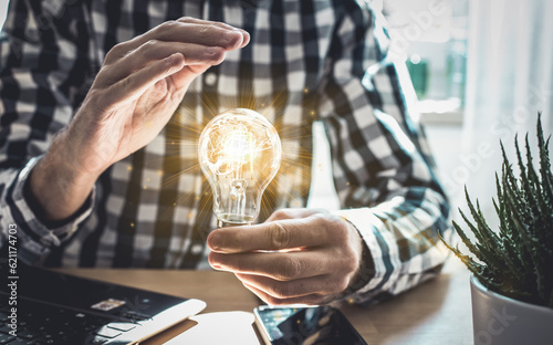 Businessman hand holding lightbulb with glowing virtual brain and connection line to creative smart thinking for inspiration and innovation with network concept.