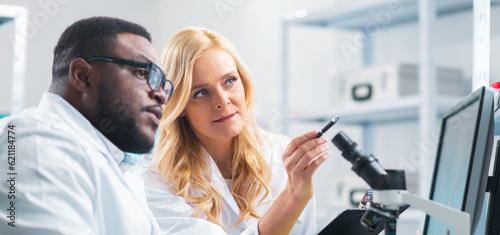 Medical scientists working in lab. Doctor teaching interns to make analyzing research. Laboratory tools: microscope, test tubes, equipment. Science and health care concept.
