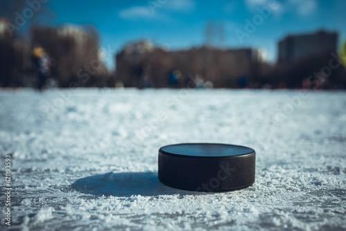 black hockey puck lies on ice at stadium