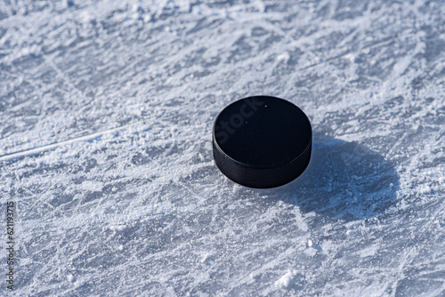 Photography hockey puck lies on the snow close-up