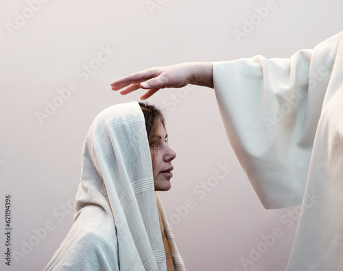 Blessing hand above the head of a woman in a headscarf