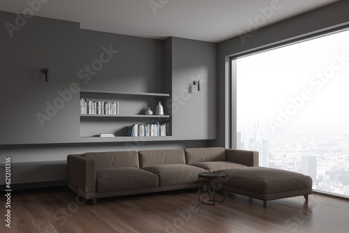 Dark living room interior with couch and shelf with decor, panoramic window