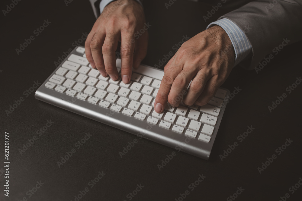 Person typing on a computer keyboard, businessman is working in a startup company's office, he is typing messages to his colleagues and making financial documents summarizing the meetings. Person typing on a computer keyboard, businessman is working in a startup company's office, he is typing messages to his colleagues and making financial documents summarizing the meetings.
