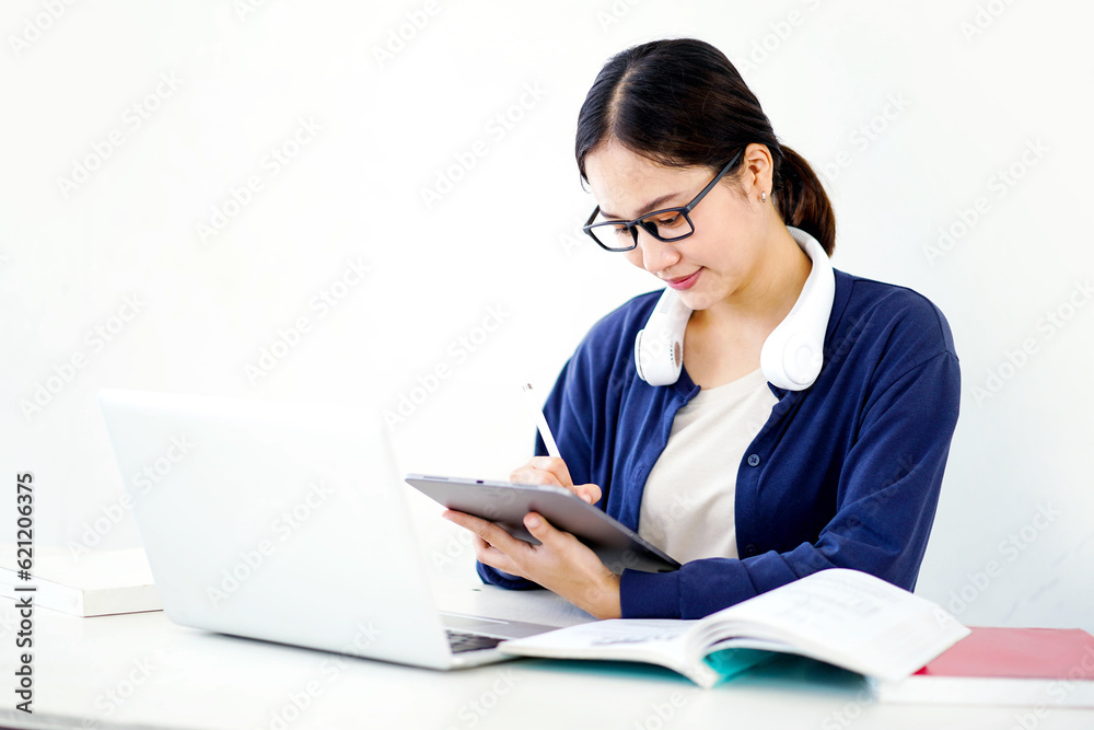 Closeup Asian young female student in casual cloth make a short note on tablet for the exam on white gradient background. Asian school concept. Closeup Asian young female student in casual cloth make a short note on tablet for the exam on white gradient background. Asian school concept.