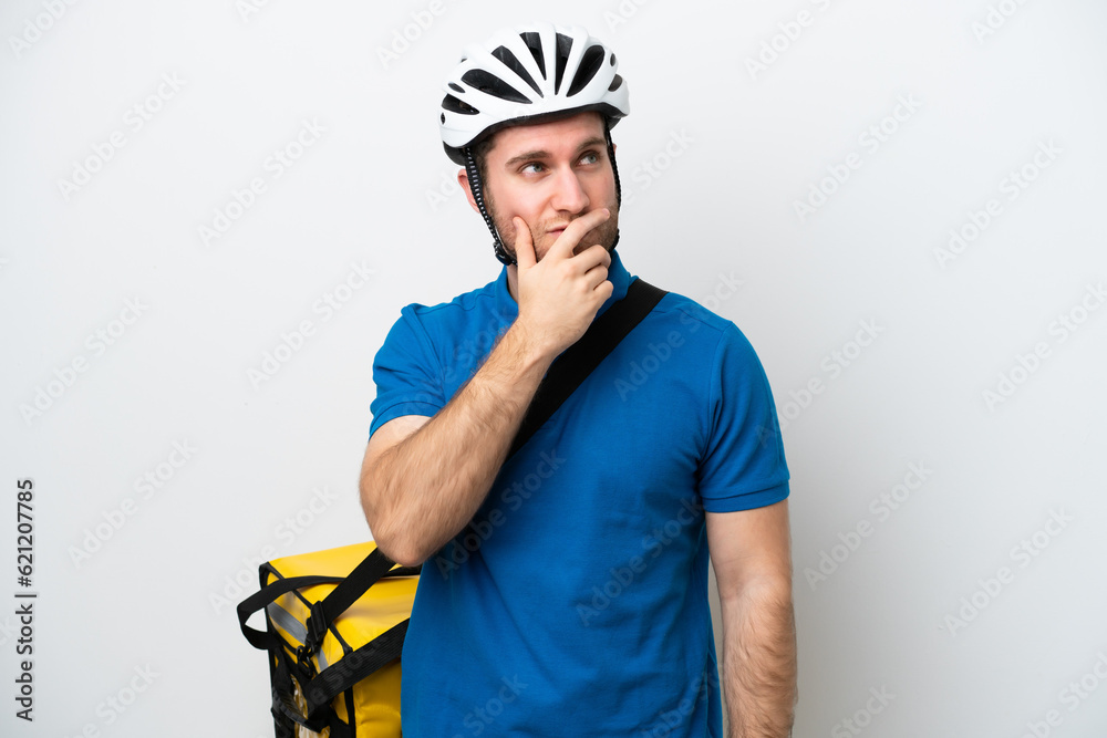 Young caucasian man with thermal backpack isolated on white background having doubts and with confuse face expression