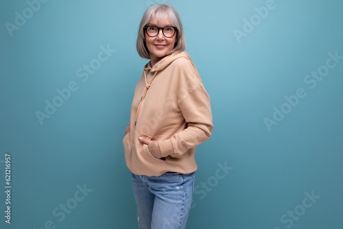 mature woman with gray hair in casual look on studio background with copy space