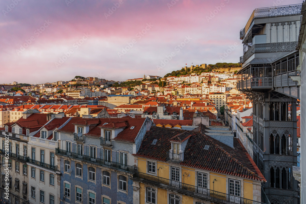 View of the Santa Justa elevator next to old buildings,with the castle of Saint George in the background,Lisbon,Portugal.