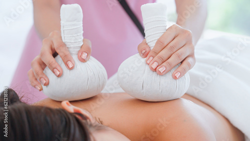 Woman spa with Thai herbal ball hot compress massage.