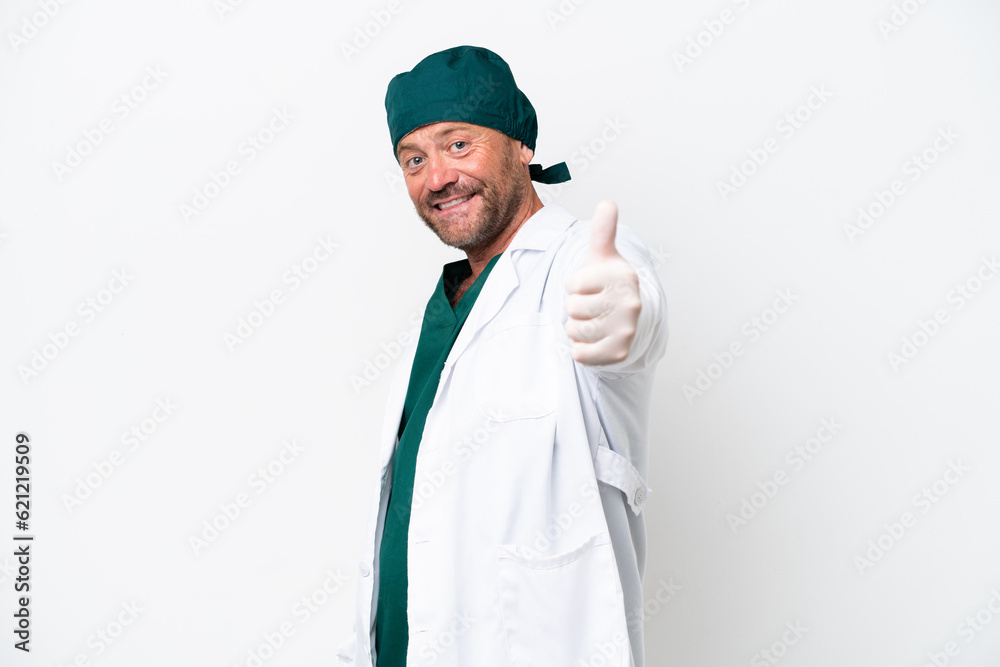 Middle age surgeon in green uniform isolated on white background with thumbs up because something good has happened Middle age surgeon in green uniform isolated on white background with thumbs up because something good has happened