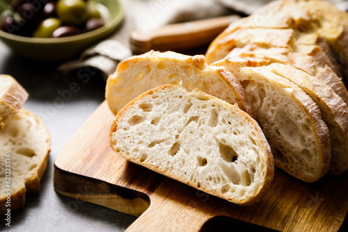 Fotografie, Obraz Ciabatta bread sliced on a board