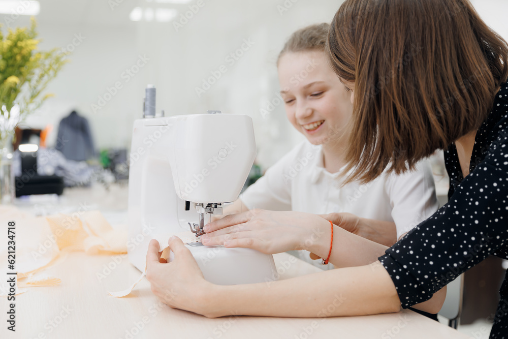Little girl working with modern sewing machine on seamstress master class Little girl working with modern sewing machine on seamstress master class