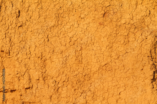texture of natural orange cracked clay as wall background