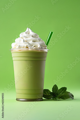 Green tea frappucino with whipped cream in a takeaway cup isolated on green background