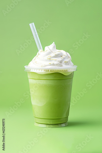 Green tea frappucino with whipped cream in a takeaway cup isolated on green background