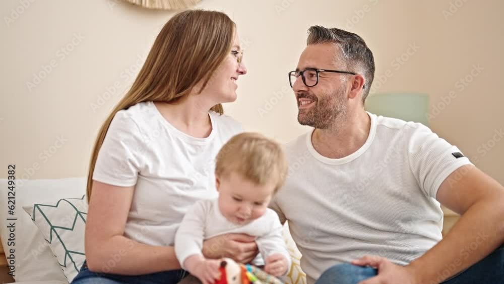 Family of mother, father and baby together sitting on the bed at bedroom Family of mother, father and baby together sitting on the bed at bedroom