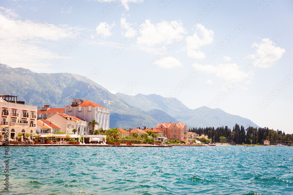 View from sea to sunny European town. Mountains in background. Travel and summer. Copy space. Adriatic land